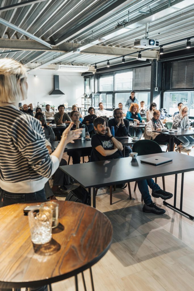 pexels-photo-18999485-18999485 A presenter engages an attentive audience during a business workshop indoors.